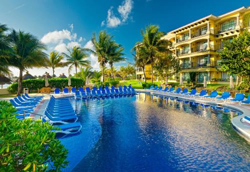 莫雷洛斯港玛里娜艾尔西德Spa及海滩全包度假村的一个带椅子的游泳池和一座建筑的度假胜地