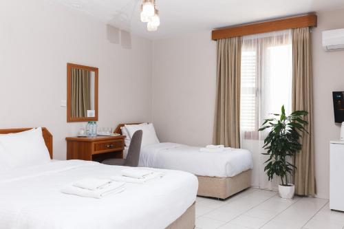 凯里尼亚Homelike Guest House的酒店客房设有两张床和窗户。