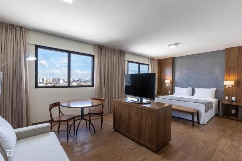 乌贝兰迪亚Gran Executive Hotel的配有一张床和一台平面电视的酒店客房