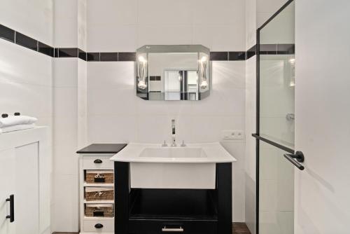 布兰肯贝赫Kolonel - Charmant & lichtrijk app aan zee 4p的白色的浴室设有水槽和淋浴。
