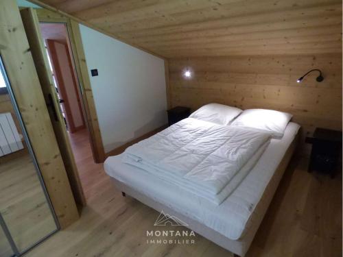 Le ChinaillonAppartement Le Grand-Bornand, 2 pièces, 6 personnes - FR-1-458-178的木质客房的一张床位,铺有木地板