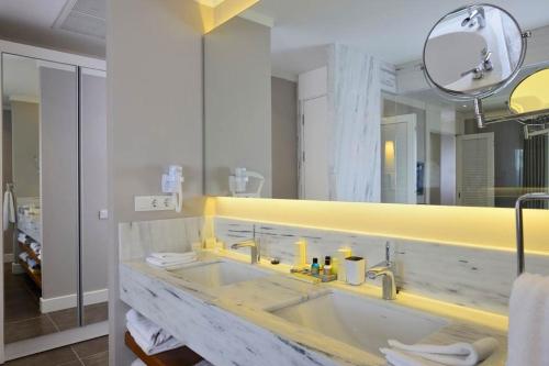 图尔古特雷斯Sundance Suites Hotel的一间带水槽和大镜子的浴室