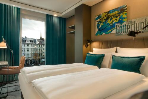 波恩Motel One Bonn-Beethoven的酒店客房设有两张床和窗户。