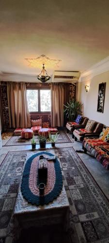 开罗Panorama apartment with a charming view of Cairo International Airport All the apt for you with free airport pick up or drop off limousine شقة بانوراما بإطلالة ساحرة على مطار القاهرة الدولي的客厅配有沙发和桌子