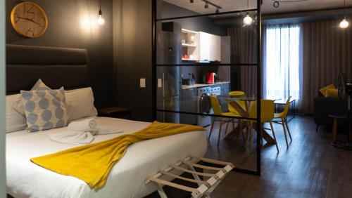 开普敦Wex1 Style living的一间卧室配有一张大床,床上有黄色的毯子