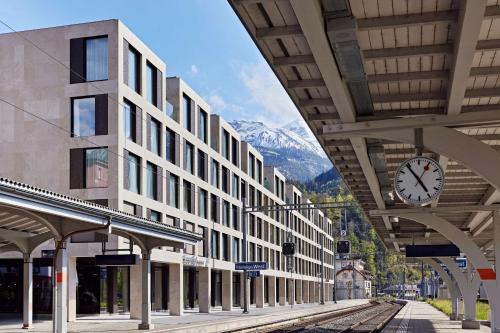 因特拉肯Essential by Dorint Interlaken - New Opening的挂在建筑物上的钟表的火车站