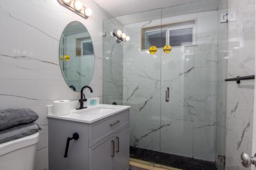 好莱坞Pousada suites的带淋浴、盥洗盆和镜子的浴室