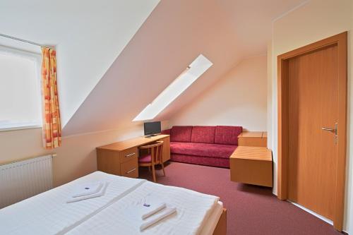 斯托泽克酒店捷克斯莱比酒店的一间设有床铺和红色沙发的房间
