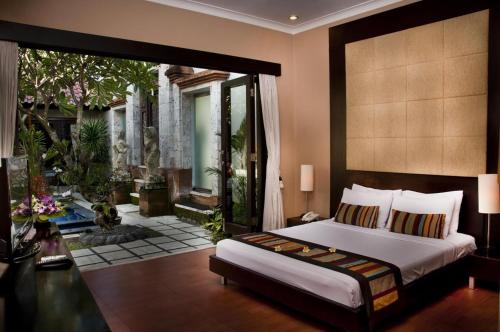 沙努尔信德梅特套房酒店的一间带大床的卧室和一个露台