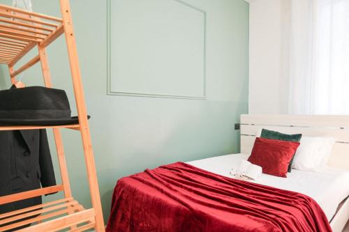 都灵Maison Métropole Turin的一间卧室配有一张带红色床单和梯子的床
