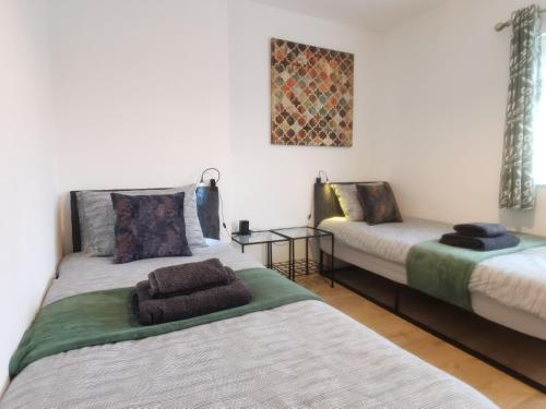 诺丁汉Contemporary 3 bedroom house的客房设有两张床、一张沙发和一张桌子。