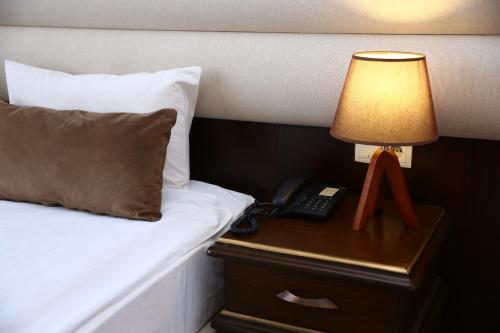 巴库Smith Hotel Baku的床头灯和床头柜上的电话