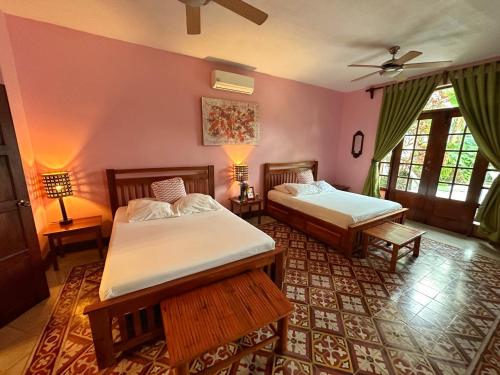 格拉纳达Hotel La Polvora的配有粉红色墙壁的客房内的两张床