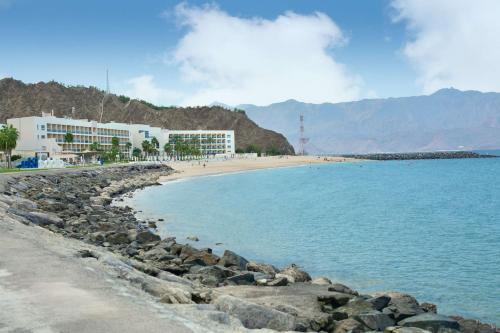 迪巴富吉拉丽笙度假酒店的拥有建筑的海滩和拥有岩石的海滩