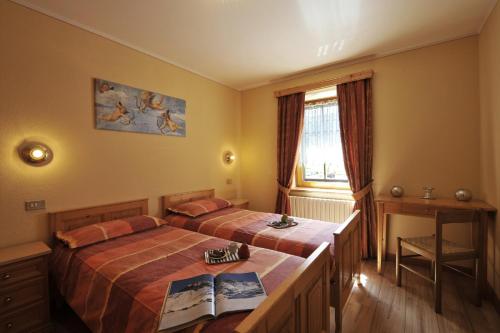 利维尼奥Genziana - Happy Rentals的一间卧室设有两张床、一张桌子和一个窗口。