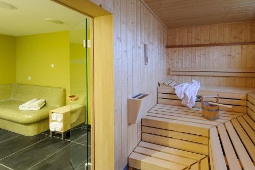 慕尼黑诺富特慕尼黑市阿努尔福帕克酒店的一间室内带长椅和椅子的桑拿浴室