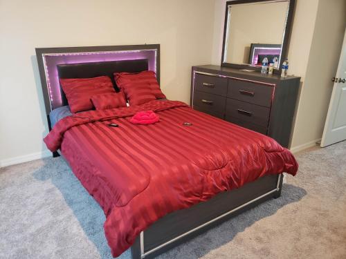 基西米Troy@Kissimme的一间卧室配有一张带红色被子和镜子的床