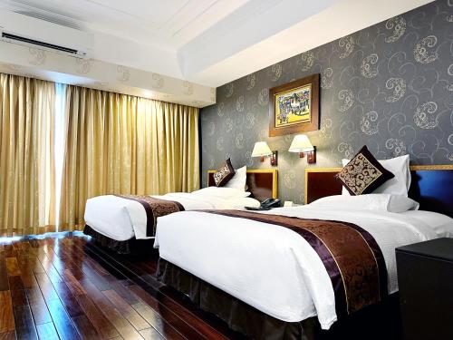 胡志明市雷克斯酒店的一间酒店客房,房间内设有三张床