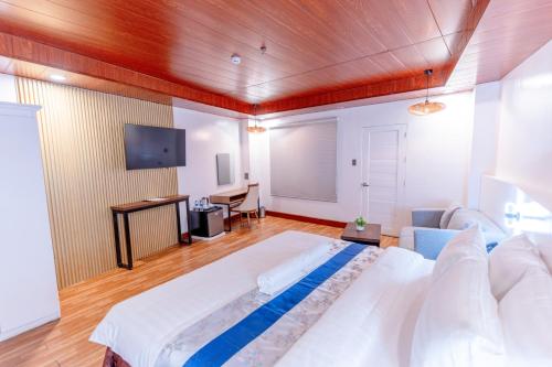 SantiagoSantiago Cove Hotel and Restaurant的一间大卧室,配有一张大床和一台平面电视