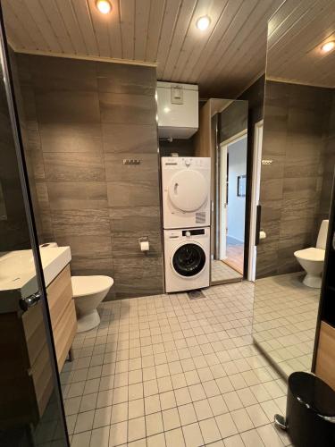 瓦萨Ihana huoneisto - The Nest with Sauna in VAASA的浴室配有洗衣机和烘干机。