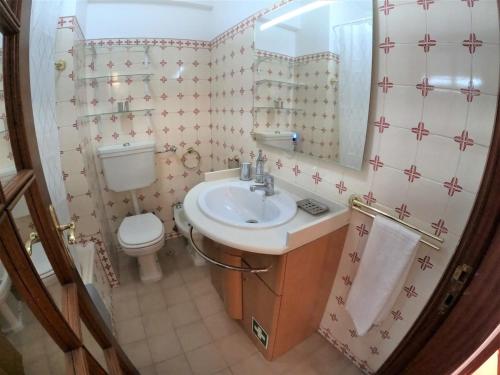 琳达阿韦立亚Lisbon T2 apartment in condominium in Linda-a-Velha Oeiras Lisbon的一间带水槽、卫生间和镜子的浴室