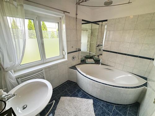 因斯布鲁克Haus Sunnseitn的白色的浴室设有浴缸和水槽。