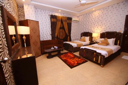 拉合尔Premier Inn Johar Town Lahore的一间卧室配有两张床、一把椅子和一张沙发
