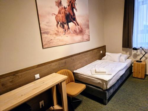 松博特海伊加尔达酒店的一间卧室配有一张床,并画有马匹