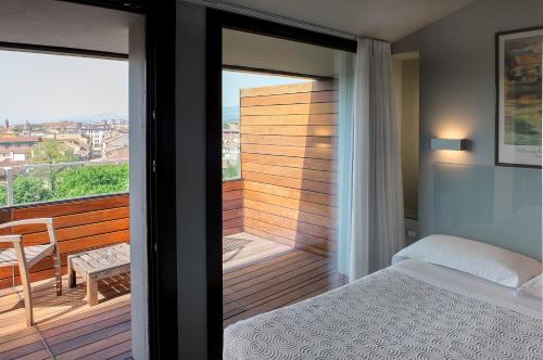 维罗纳维罗纳酒店的一间卧室设有1张床铺和1张桌子的阳台