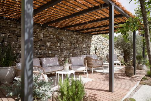 蒂鲁罗Feel good Resort Johannis的一个带沙发和椅子的庭院,位于木制凉棚下