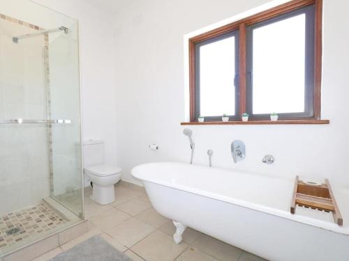 梅森堡Annies Place Muizenberg的白色的浴室设有浴缸和卫生间。