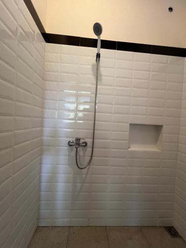 WenditDhome by Riana的白色瓷砖墙内带软管的淋浴
