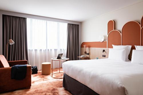 巴黎巴黎普尔曼中心 - 贝西的酒店客房带一张大床和一把椅子