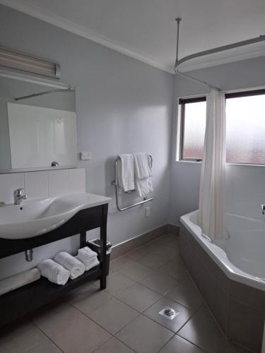 普基科希阿维达汽车旅馆的一间带水槽、浴缸和镜子的浴室