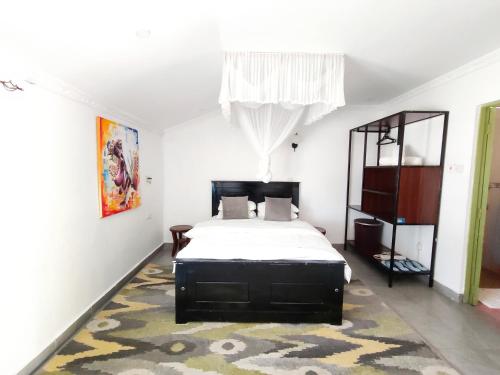 基苏木MILIMANI DRIVE LIVINGs的一间卧室配有一张床和地毯
