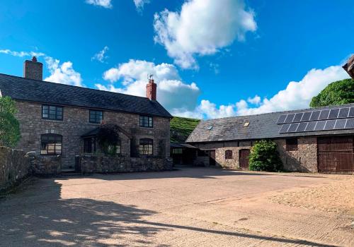 奥斯威斯Cynynion Uchaf - Countryside Farmhouse with Views的一座古老的石头建筑,上面有太阳能电池板