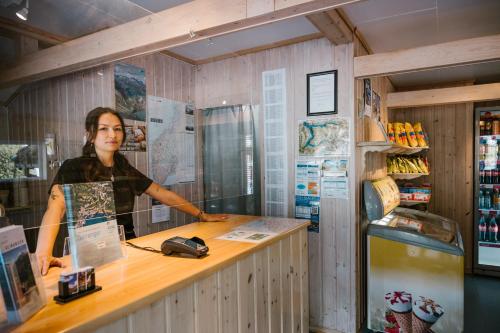 盖郎厄尔峡湾文杰露营地的站在商店柜台的女人