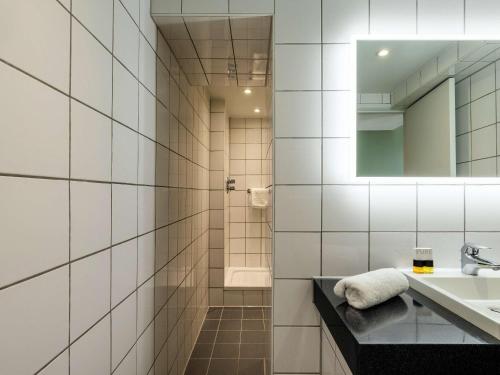 贝德福德Mercure Bedford Centre Hotel的白色瓷砖浴室设有水槽和镜子