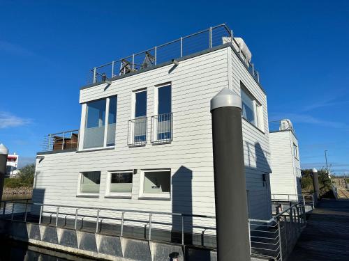 卡珀尔恩Schwimmendes Haus - An Bord Zwei的一座白色的建筑,上面设有一个阳台