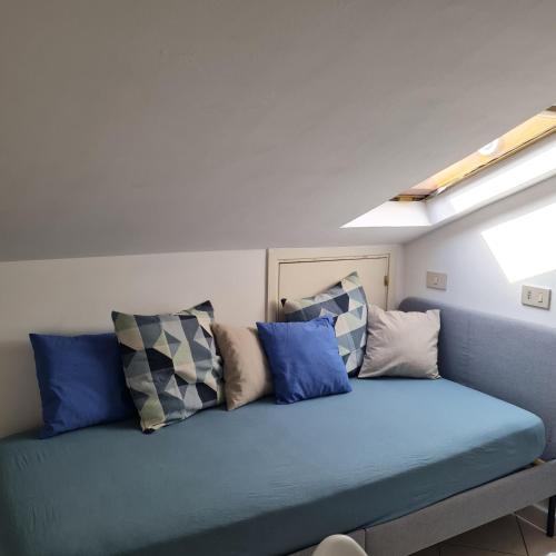圣焦万尼泰亚蒂诺Gate 25的客房内的蓝色沙发上配有枕头