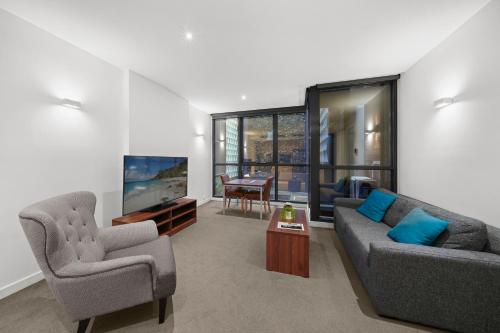 墨尔本Flinders Street Apartments的客厅配有两张沙发和一台电视机