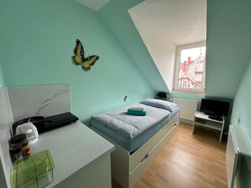 卡罗维发利Loft apartment Svahova 6的小房间,墙上有一张带蝴蝶的床