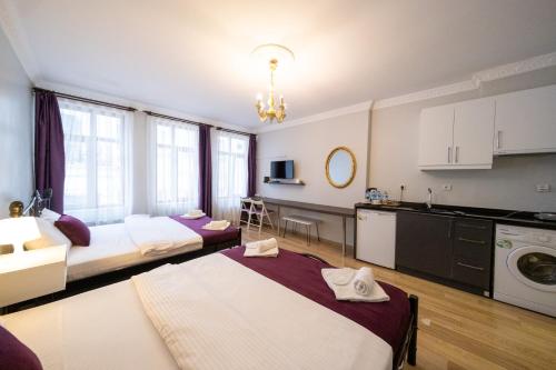伊斯坦布尔The Frame Hotel & Suites的带两张床的客房和带水槽的厨房