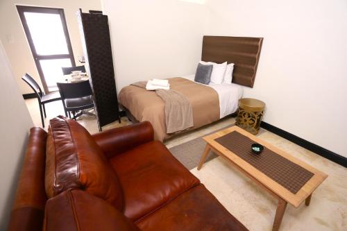 基特曼斯胡普Kitchen51 Cottages的酒店客房配有一张床和一张皮沙发