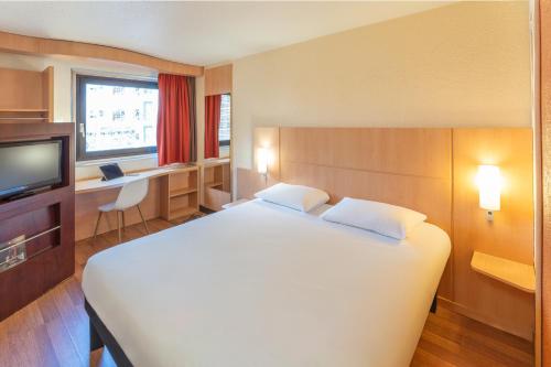 巴黎ibis Paris 17 Clichy-Batignolles的卧室配有一张白色大床和一张书桌