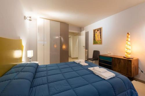 佛罗伦萨Arch Apartment Duomo - Florence的一间卧室配有一张蓝色的大床和一张书桌