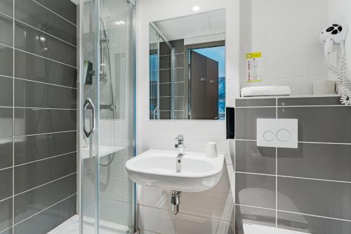 尚布雷莱图尔Kyriad Direct Tours Sud - Chambray Lès Tours的白色的浴室设有水槽和淋浴。