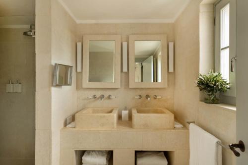 萨维勒特里博尔戈艾格纳齐亚酒店的浴室设有2个水槽和2面镜子