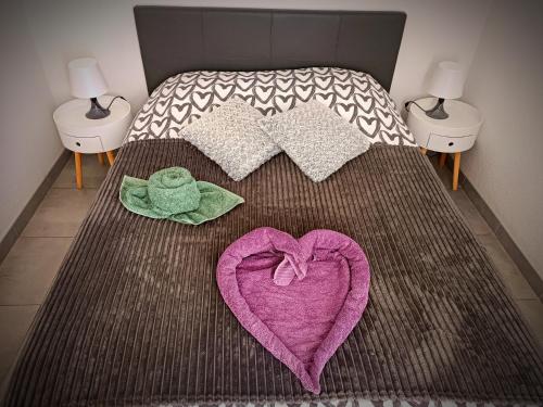 乐巴凯尔斯Chez Fifi au Barcarès的一张粉红色心和毛巾的床