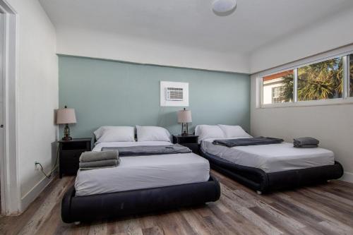 好莱坞Pousada suites的带2扇窗户的客房内的2张床